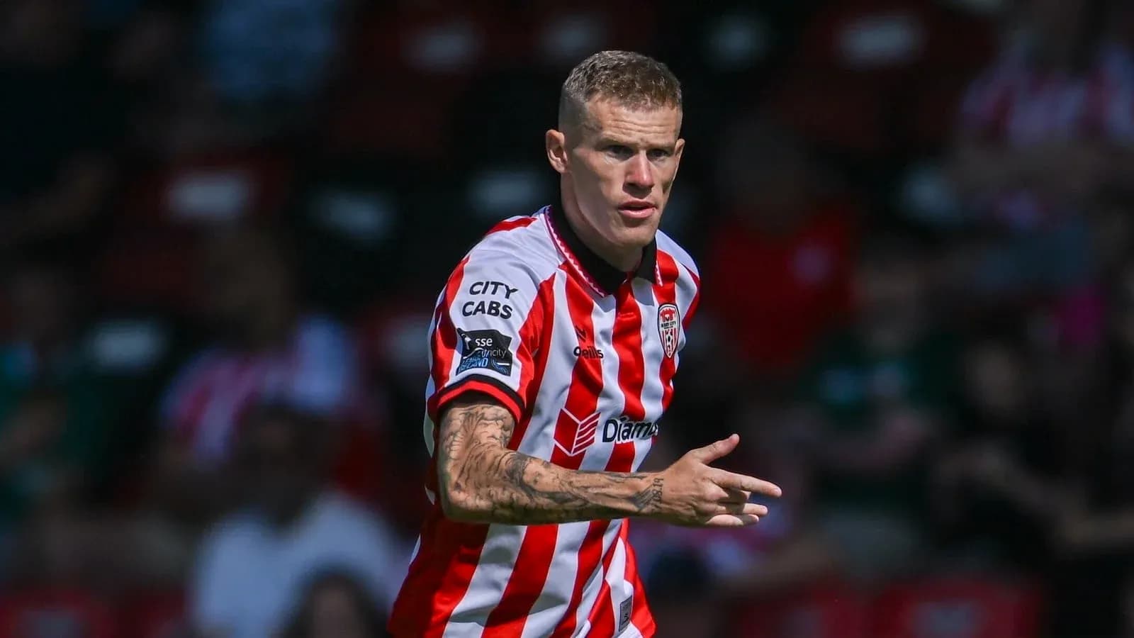 Jugador con camiseta a rayas dirigiendo en el campo