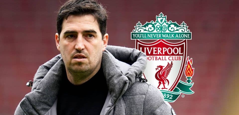 Entrenador de fútbol frente al logo de Liverpool
