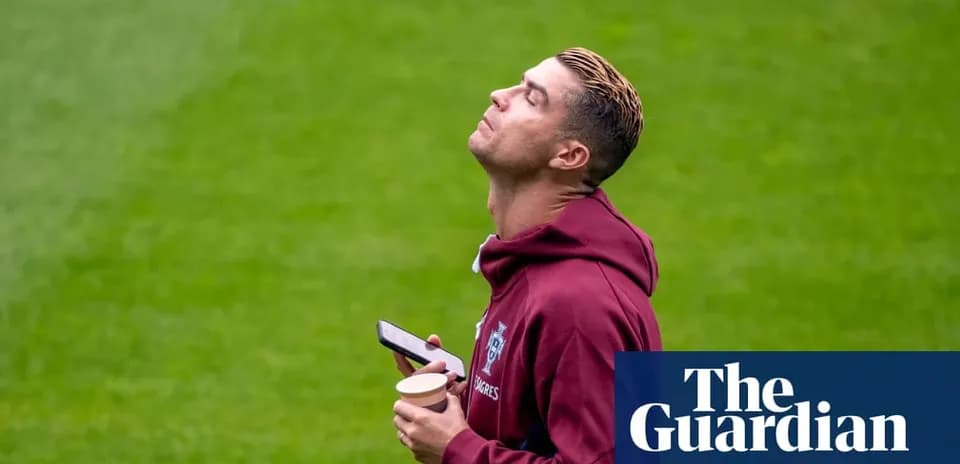 Jugador mirando al cielo con teléfono y bebida