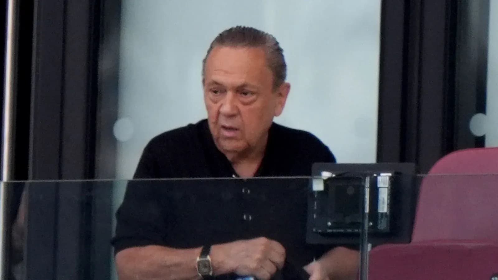 Hombre en un palco observando un evento deportivo