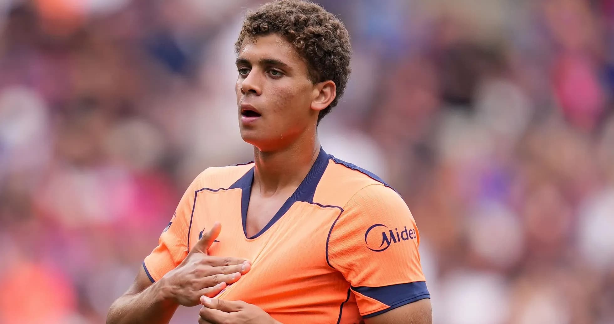 Jugador en camiseta naranja durante un partido de fútbol