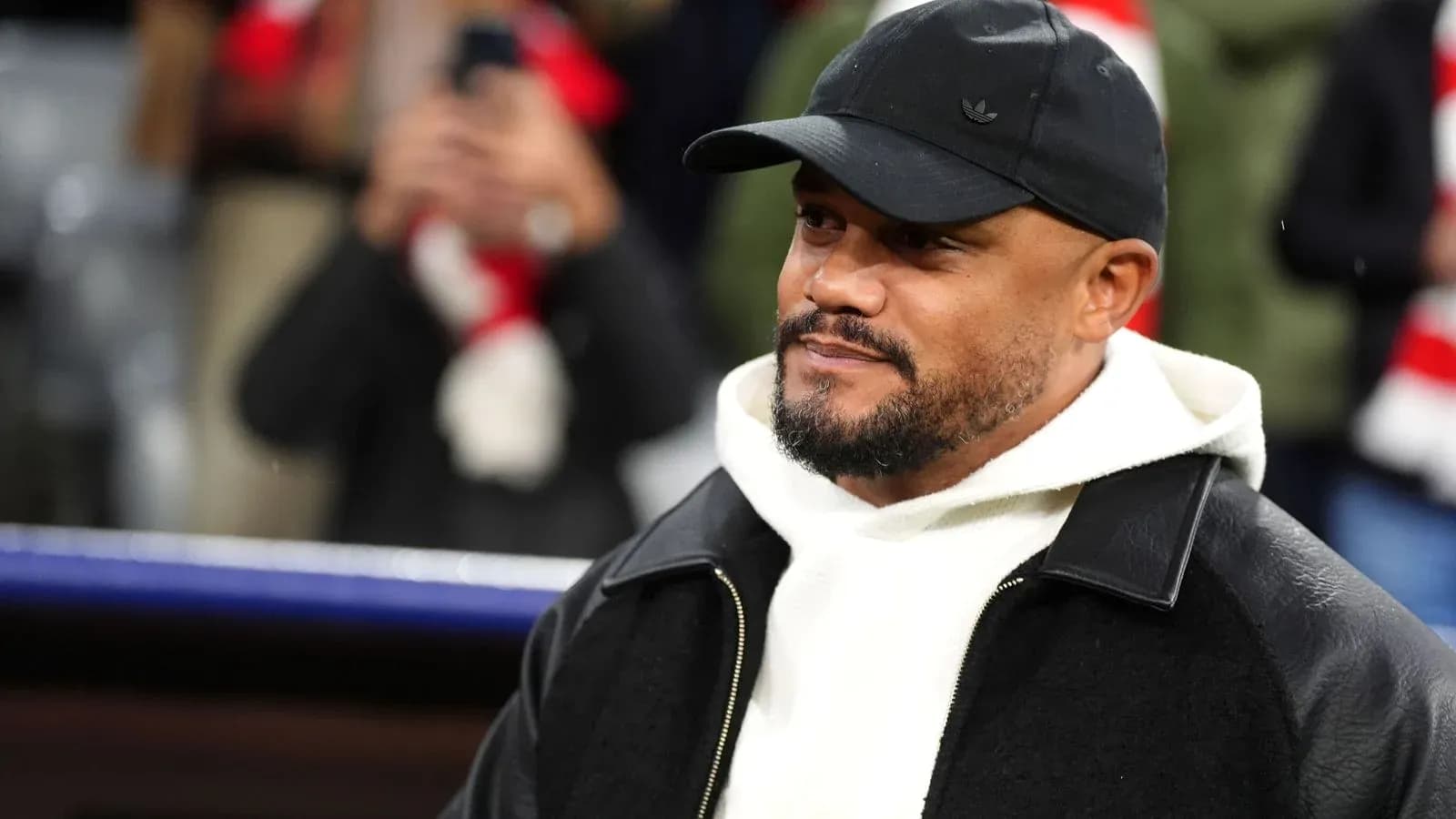 Hombre con gorra negra y chaqueta en el estadio