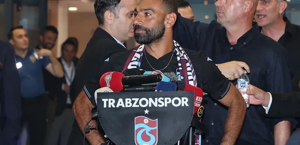 Jugador en conferencia de prensa con micrófonos y bufanda