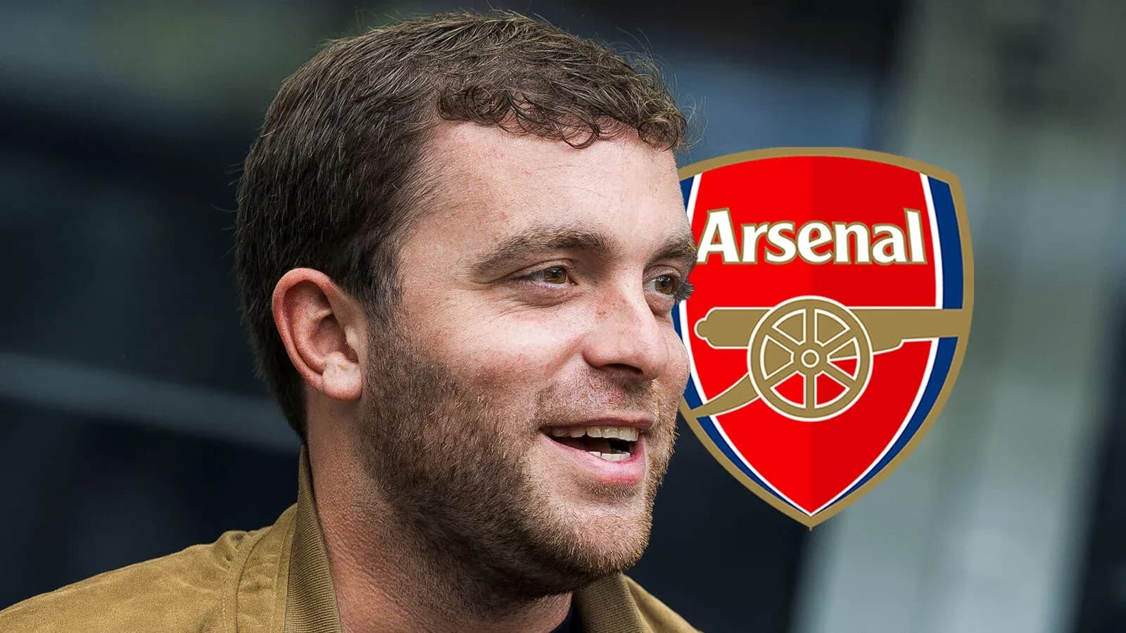 Hombre sonriendo junto al escudo de Arsenal