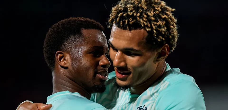 Jugadores abrazándose en celebración después de un gol
