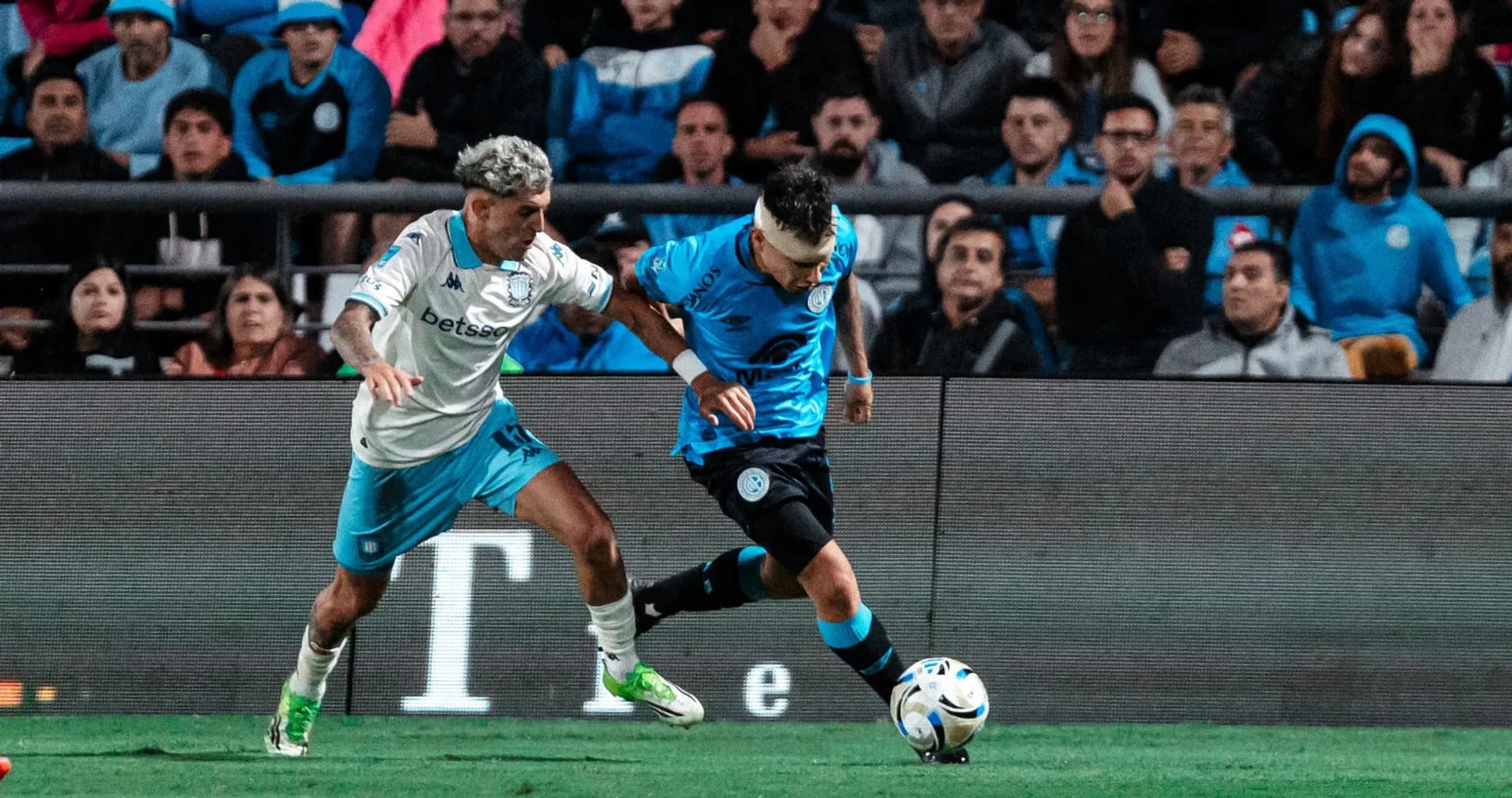 Jugador de Belgrano persigue a rival de Racing Club