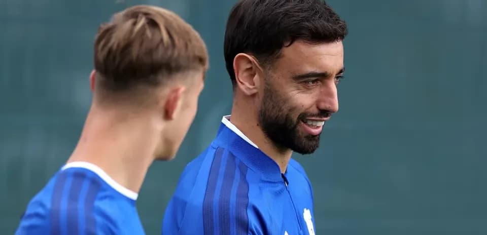 Dos jugadores conversando durante entrenamiento en el campo