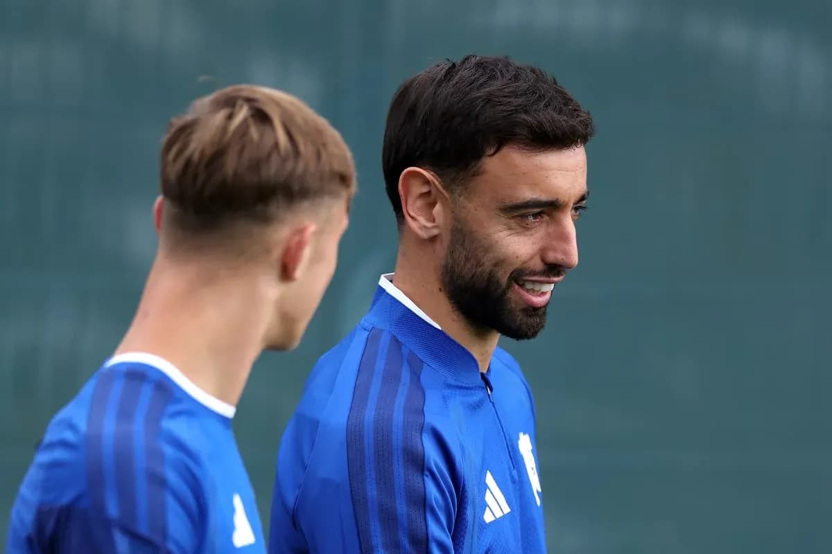 Dos jugadores conversando durante entrenamiento en el campo
