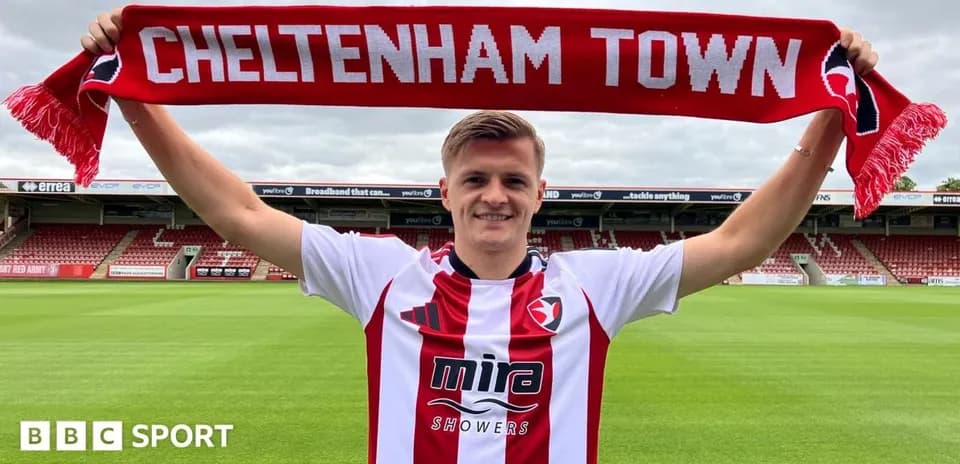 Jugador sosteniendo una bufanda de Cheltenham Town