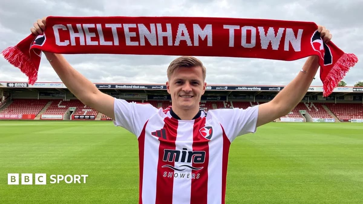 Jugador sosteniendo una bufanda de Cheltenham Town