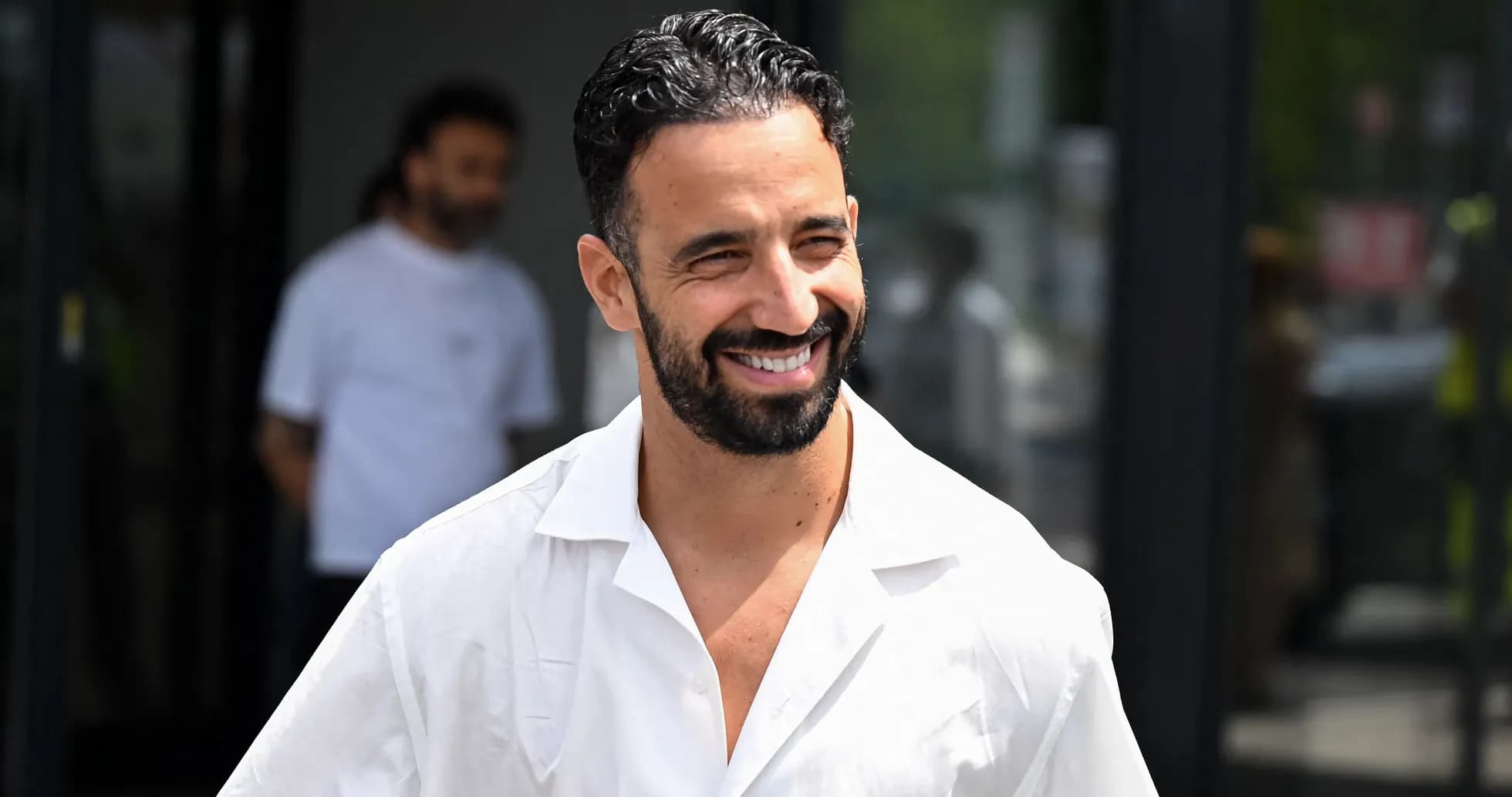 Jugador sonriendo con camisa blanca en exteriores
