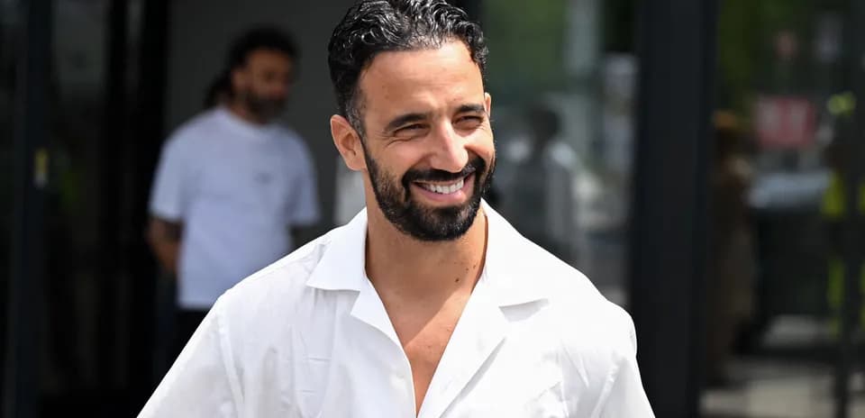 Jugador sonriendo con camisa blanca en exteriores