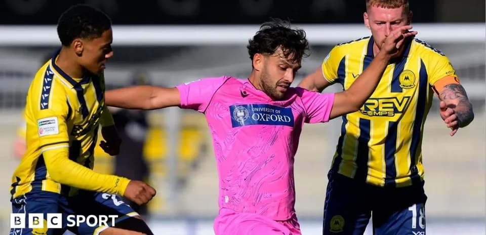 Jugador en camiseta rosa luchando por el balón