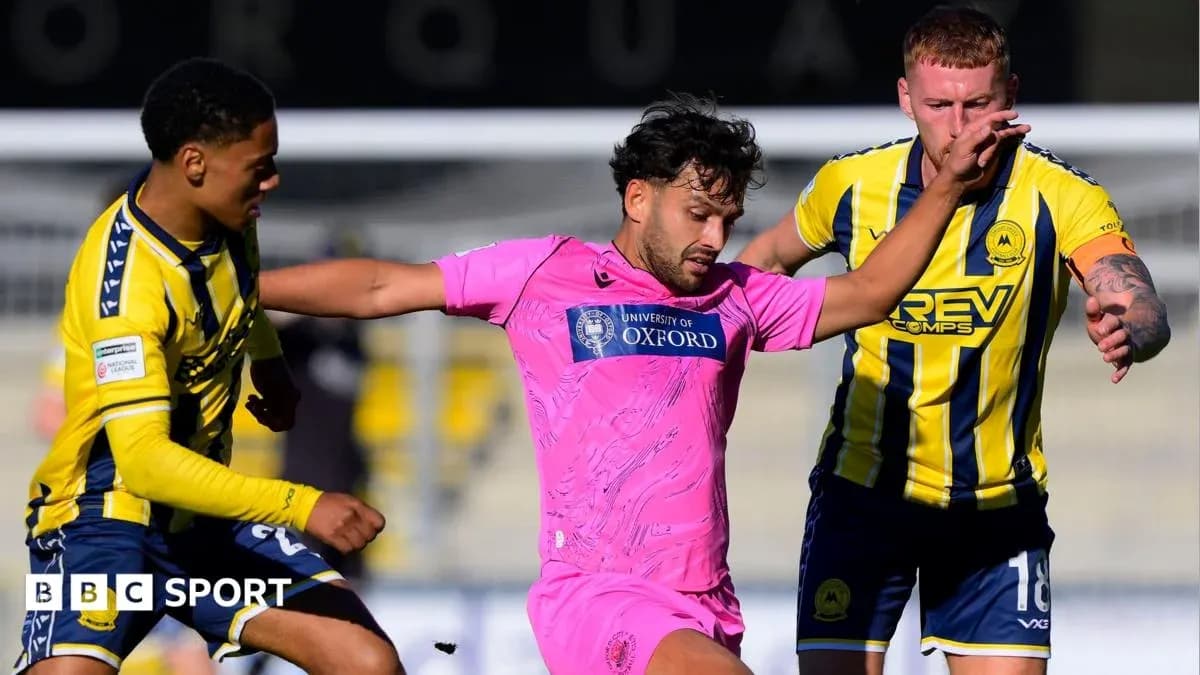 Jugador en camiseta rosa luchando por el balón