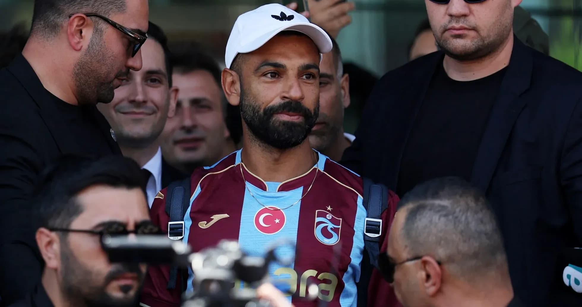 Jugador de Trabzonspor rodeado de seguridad y medios