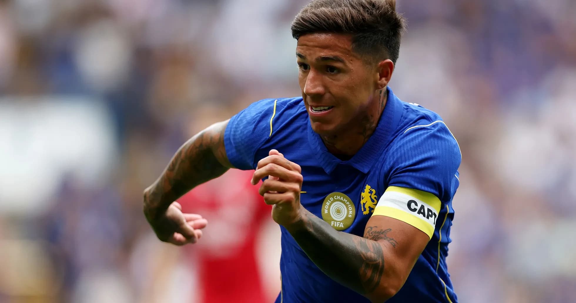 Jugador corriendo con camiseta de Chelsea y banda de capitán