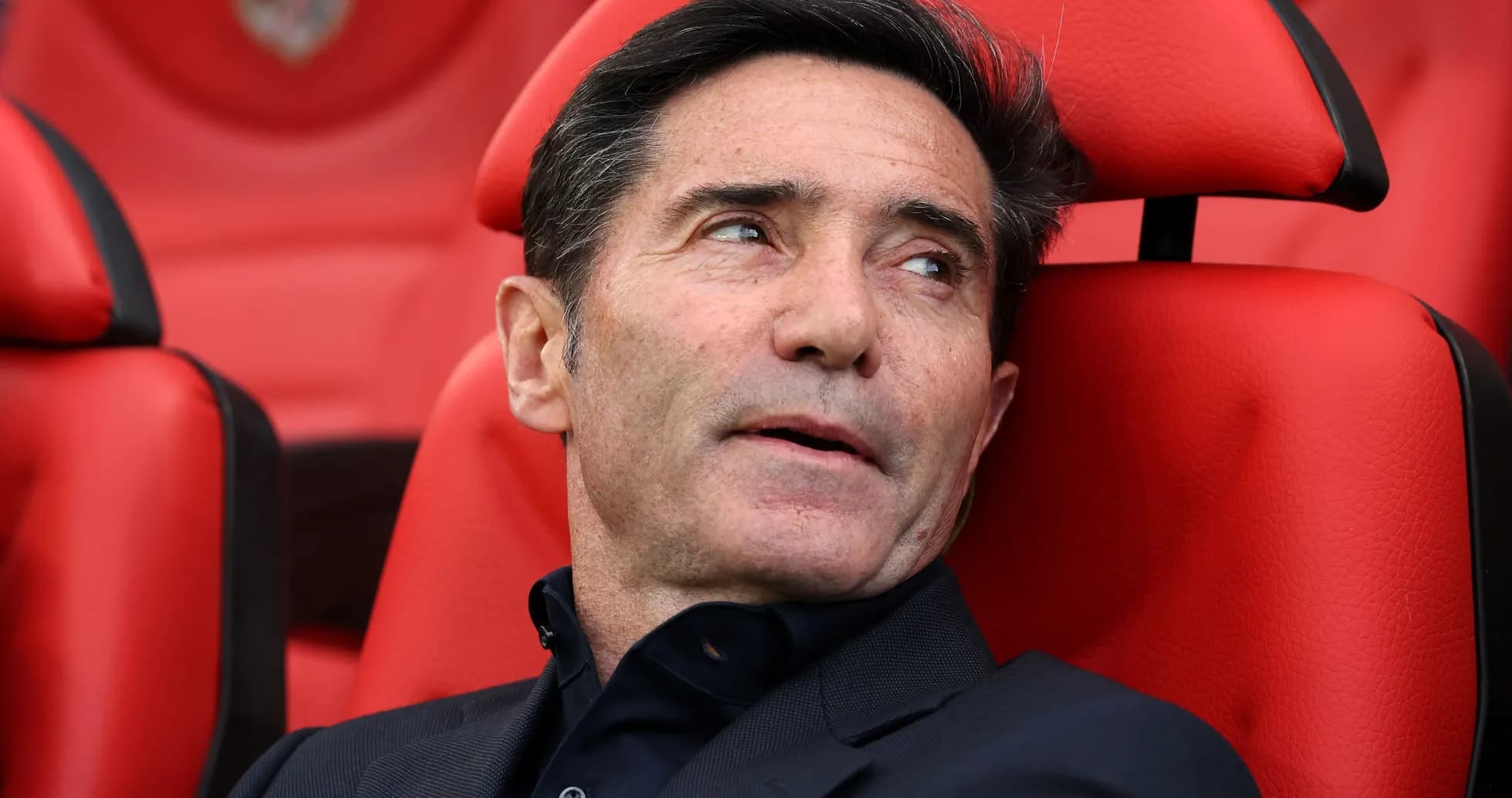 Entrenador sentado en banco de suplentes