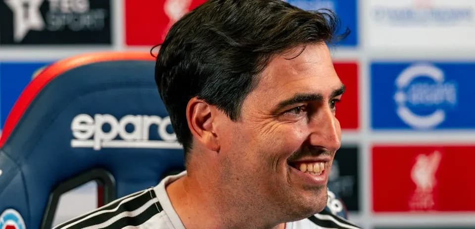 Entrenador sonriente en rueda de prensa