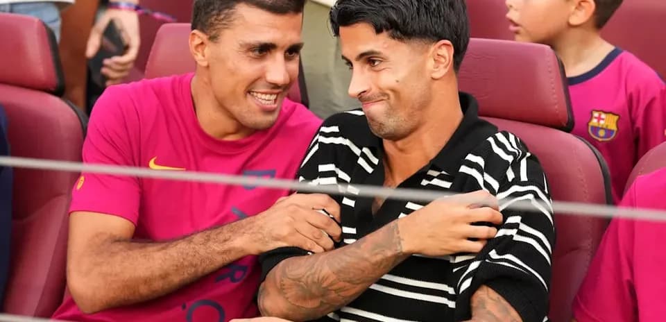 Dos jugadores sonriendo en asientos del estadio