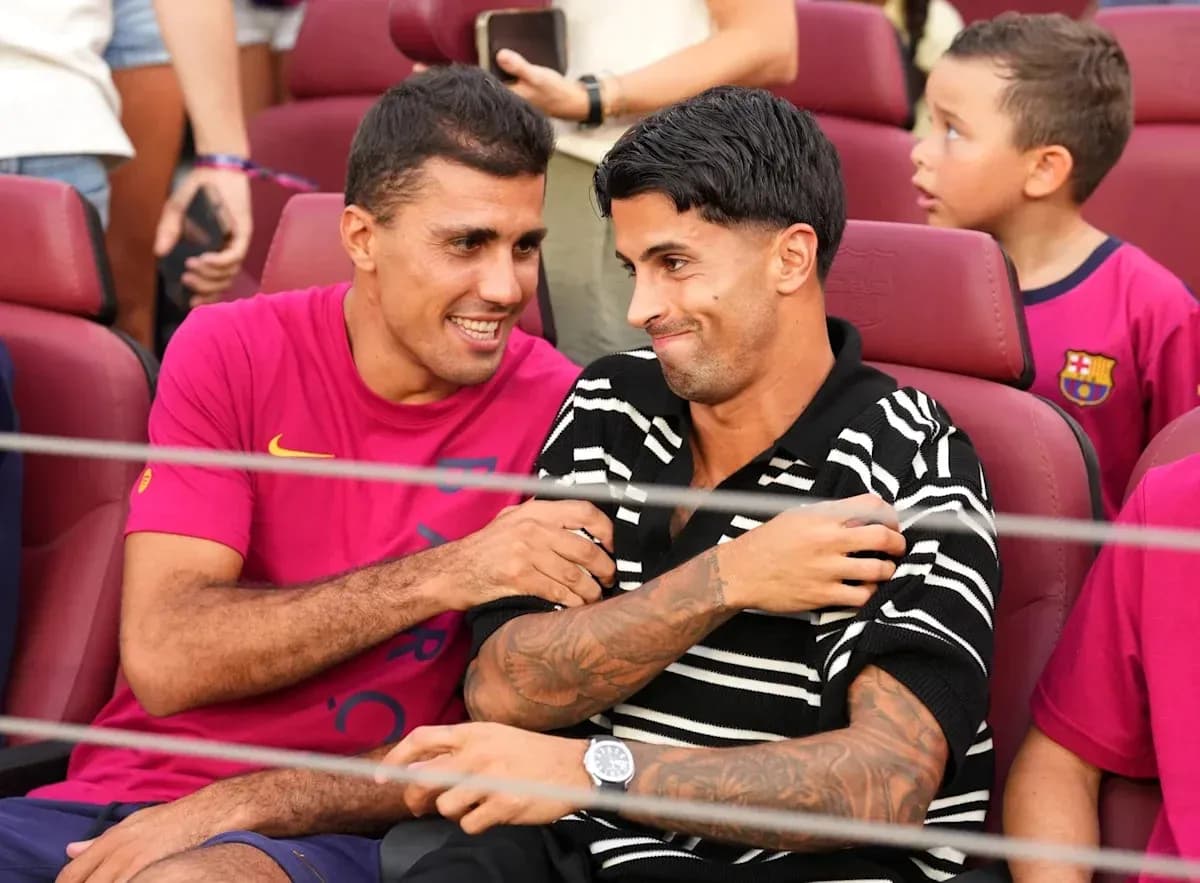 Dos jugadores sonriendo en asientos del estadio