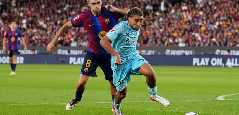 Jugador de Barcelona persiguiendo a oponente en campo