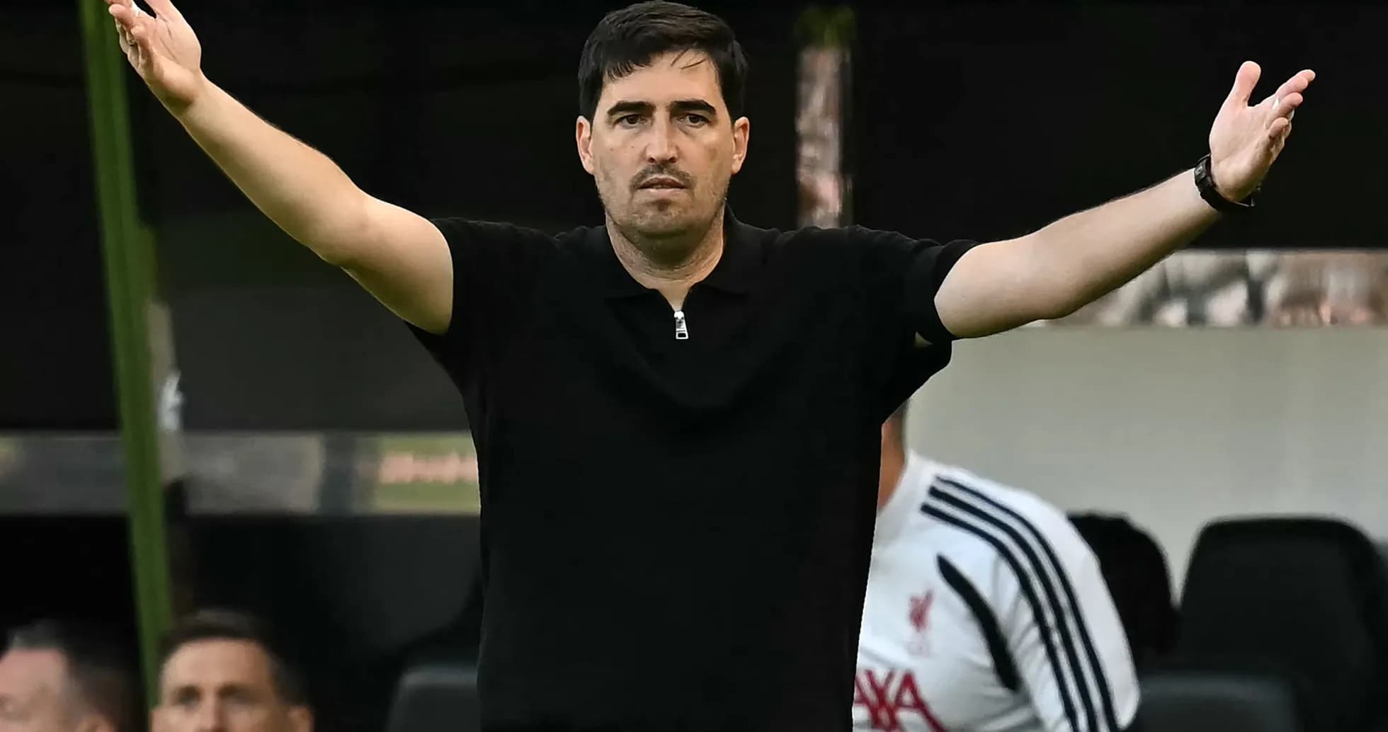 Entrenador gesticulando durante un partido de fútbol