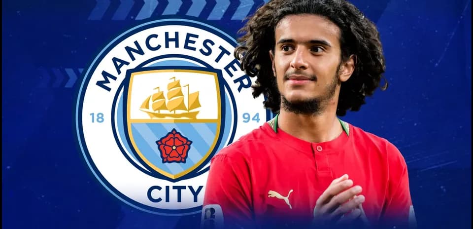 Jugador posando frente al escudo de Manchester City