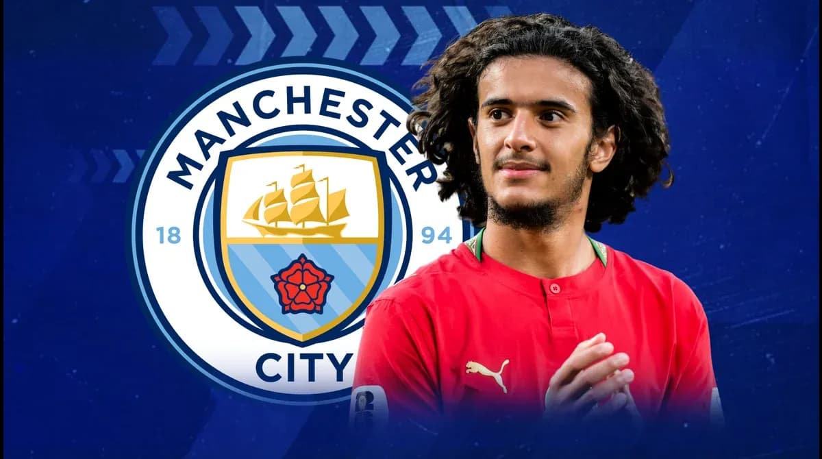 Jugador posando frente al escudo de Manchester City