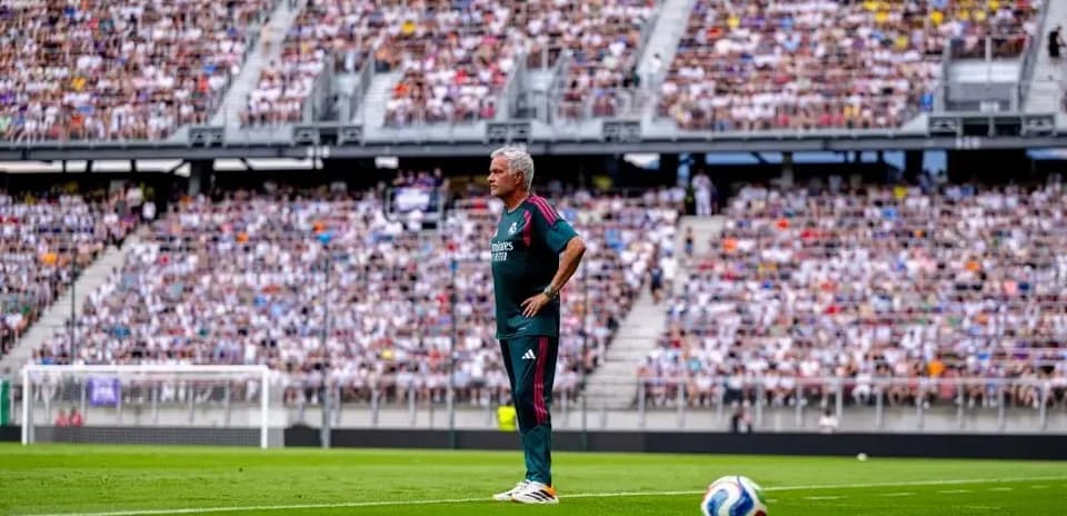 Entrenador de pie en la línea de banda durante partido
