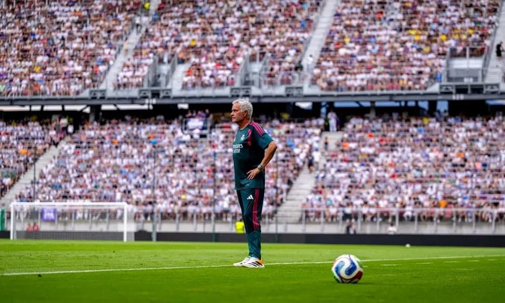 Entrenador de pie en la línea de banda durante partido