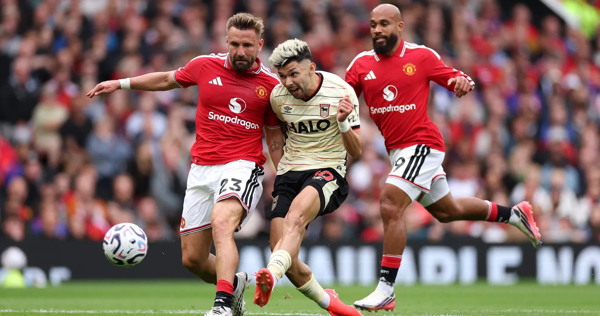 Jugador de Ipswich atacando a defensores de Manchester United