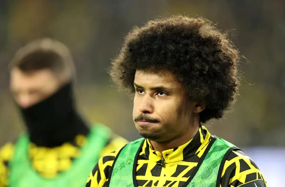 Jugador de pie en el banquillo con uniforme amarillo