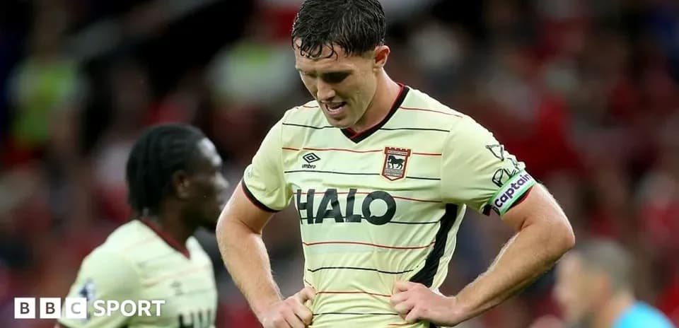 Jugador de fútbol con cabeza agachada en el campo