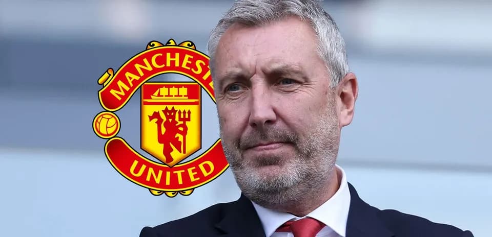 Hombre con traje frente al logo de Manchester United