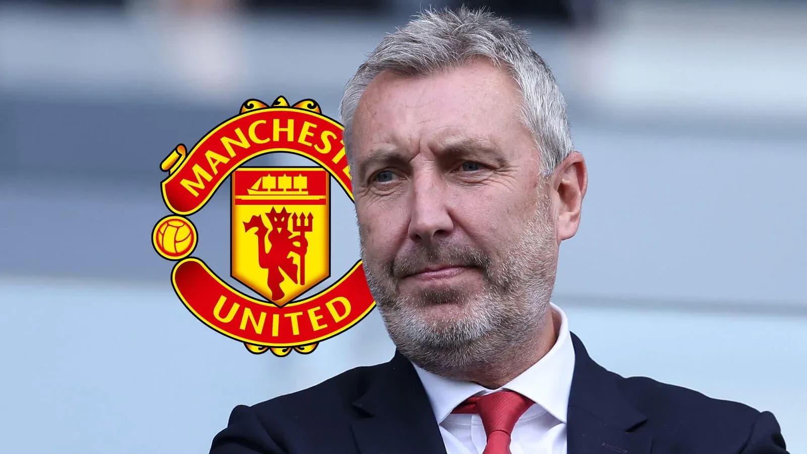 Hombre con traje frente al logo de Manchester United