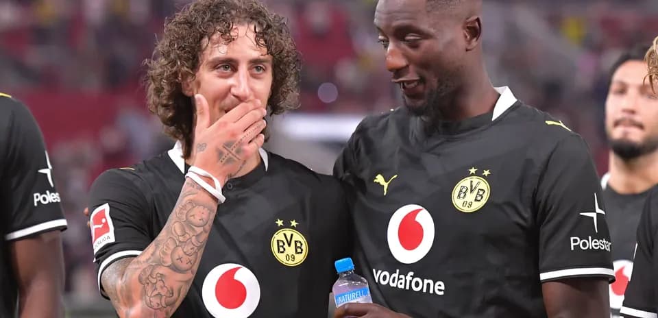Jugadores de Borussia Dortmund conversando en el campo