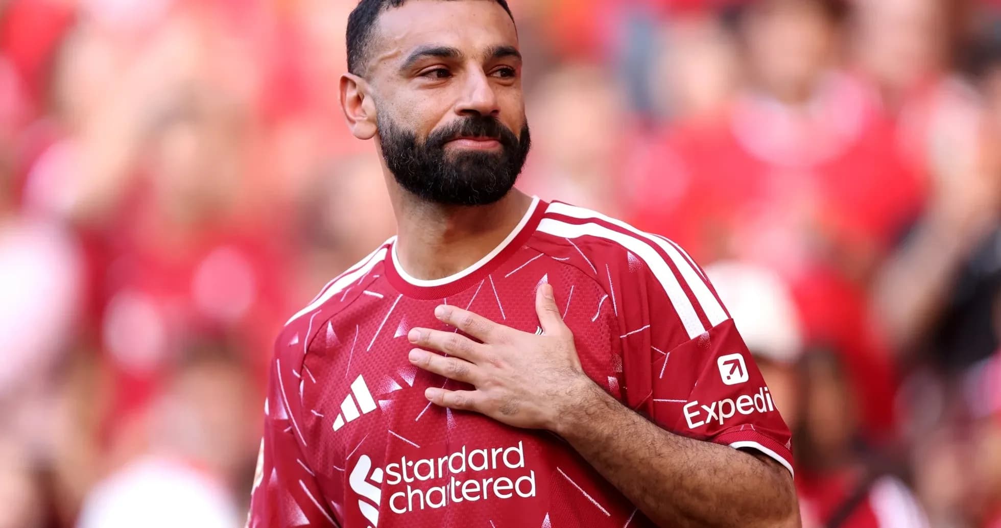 Jugador con camiseta roja saludando a la multitud Jugador con camiseta roja saludando a la multitud