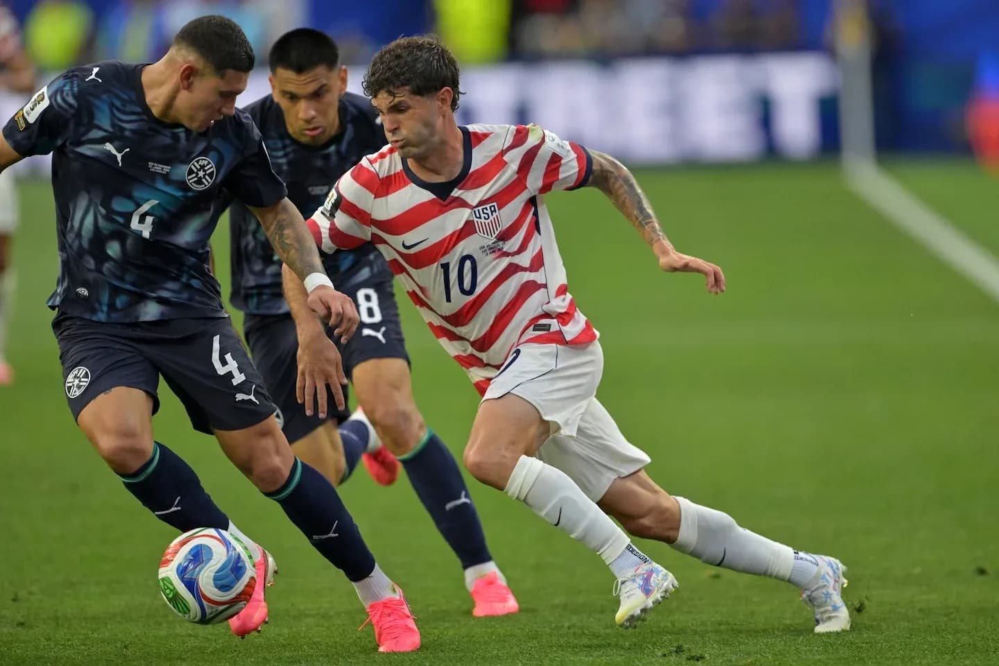Christian Pulisic dribbling past two defenders Christian Pulisic dribbling past two defenders