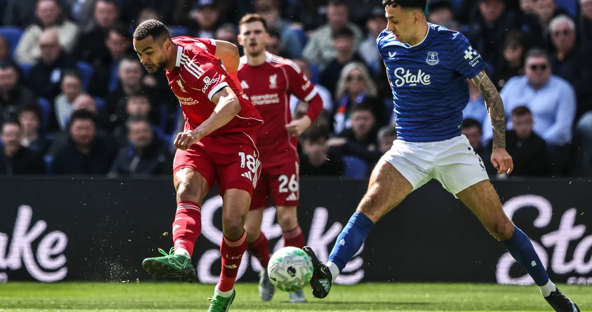 Jugador de Liverpool driblando frente a defensor de Everton Jugador de Liverpool driblando frente a defensor de Everton