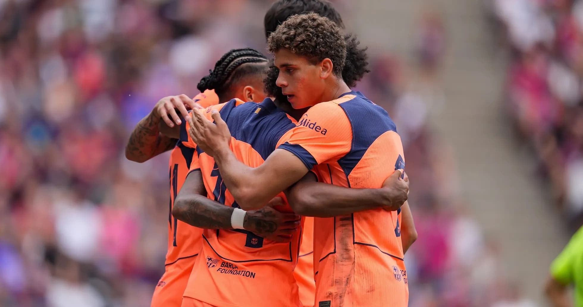 Jugadores abrazándose tras un gol en partido Jugadores abrazándose tras un gol en partido