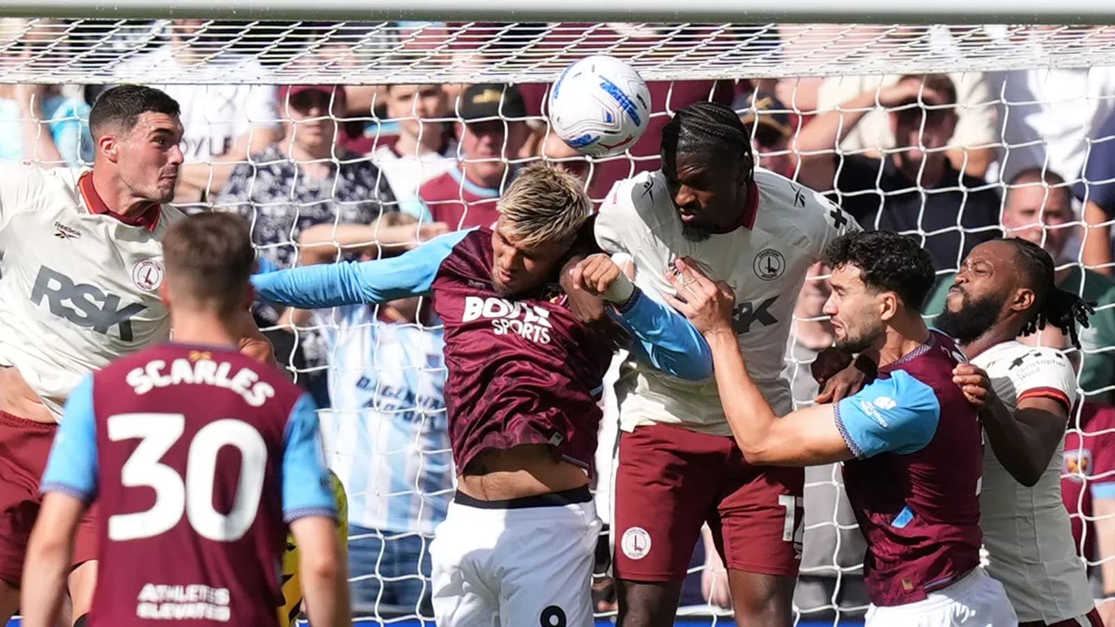 Jugadores luchando por el balón en el área de gol Jugadores luchando por el balón en el área de gol