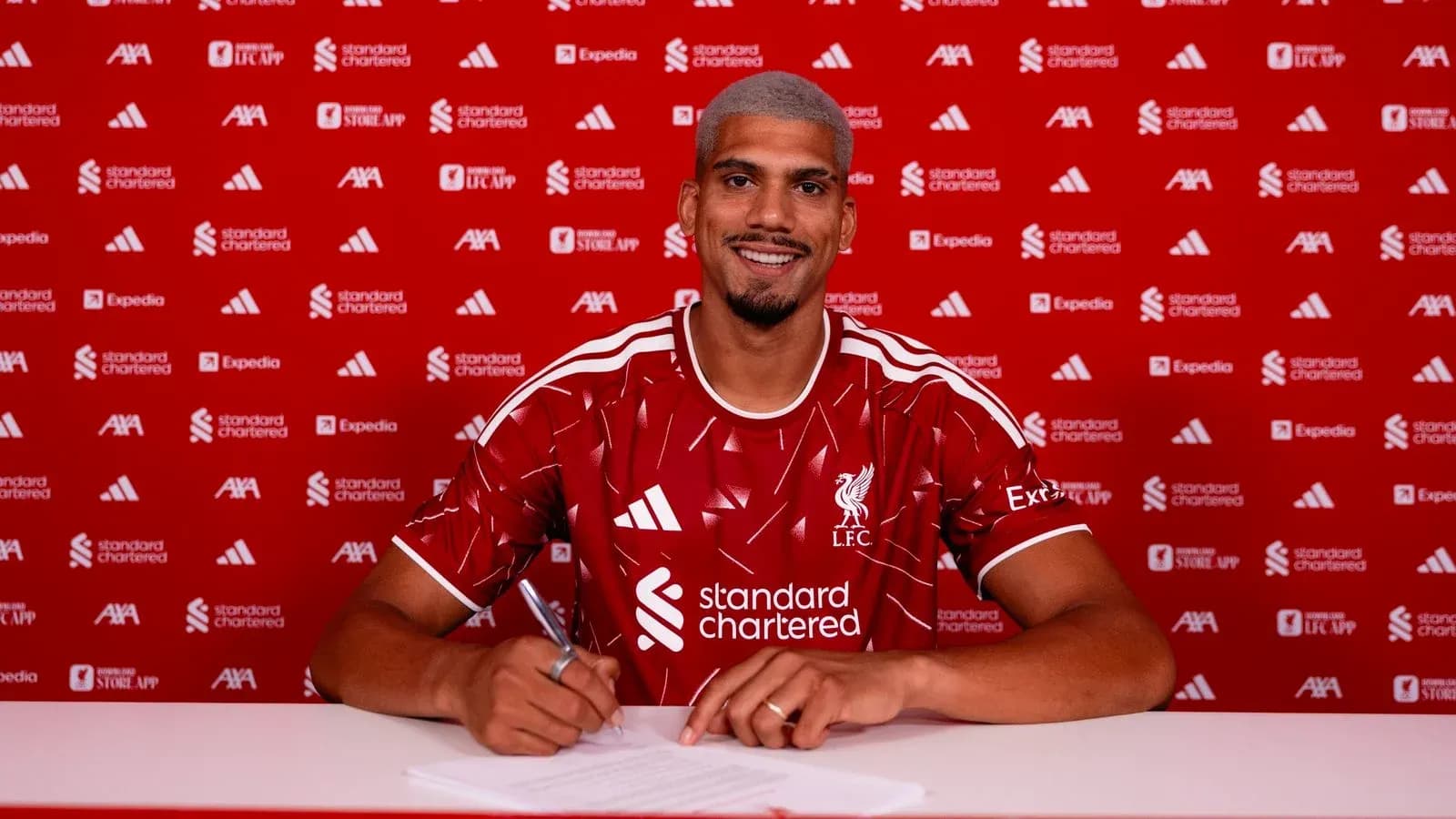 Jugador firmando contrato en presentación de Liverpool Jugador firmando contrato en presentación de Liverpool