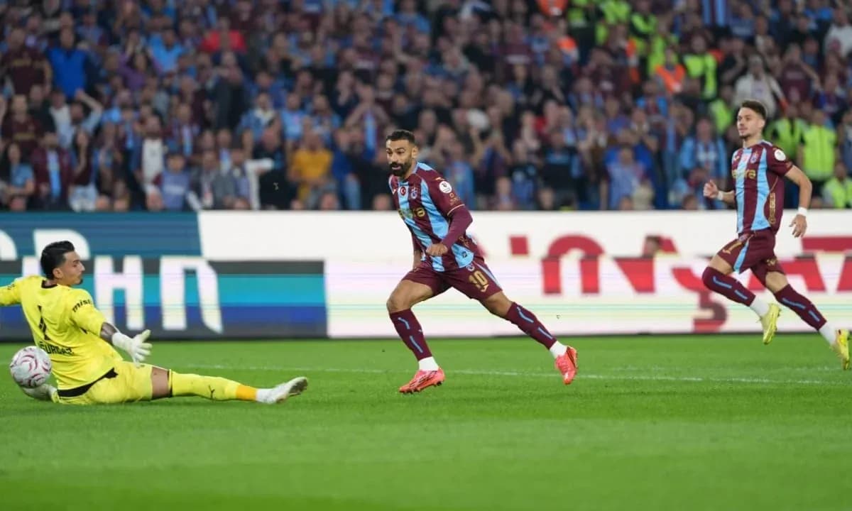 Jugador de Trabzonspor esquivando al portero en el partido Jugador de Trabzonspor esquivando al portero en el partido