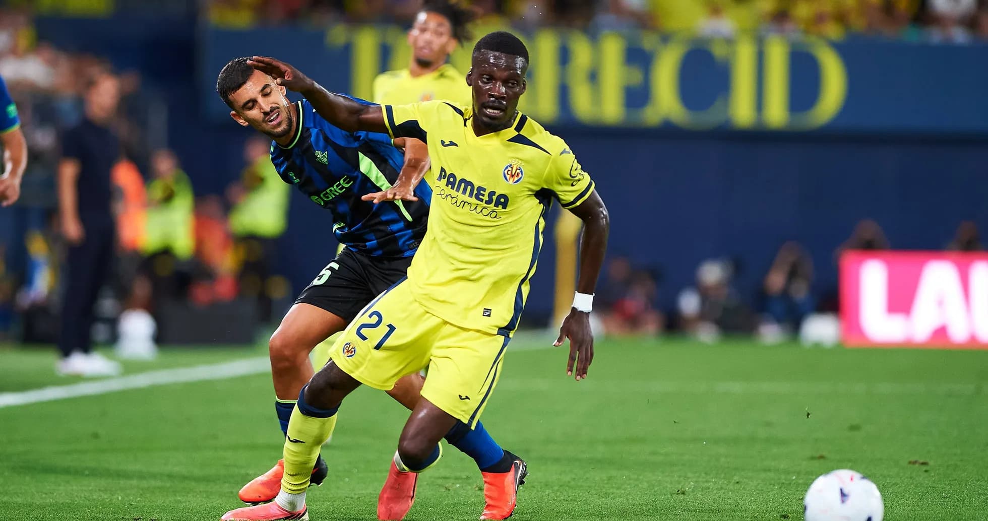 Jugador de Villarreal driblando mientras es marcado Jugador de Villarreal driblando mientras es marcado