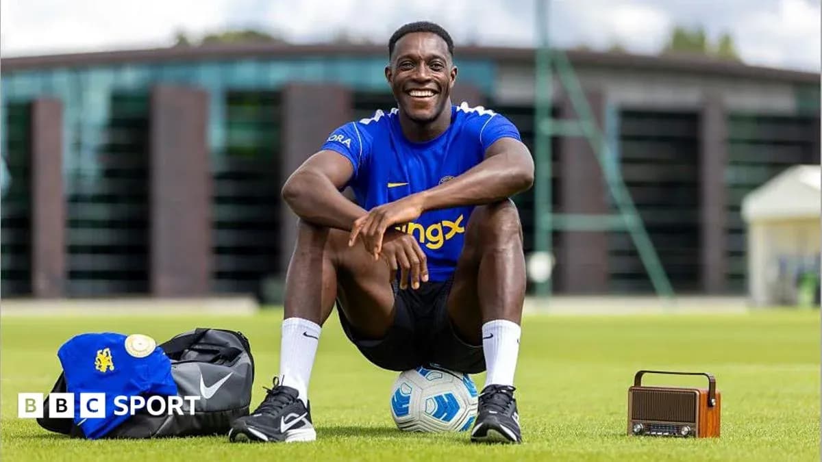 Jugador sentado en el campo con balón y mochila Jugador sentado en el campo con balón y mochila