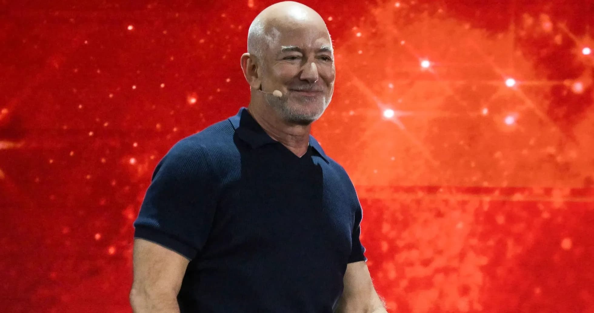 Hombre sonriendo en un escenario con fondo rojo Hombre sonriendo en un escenario con fondo rojo