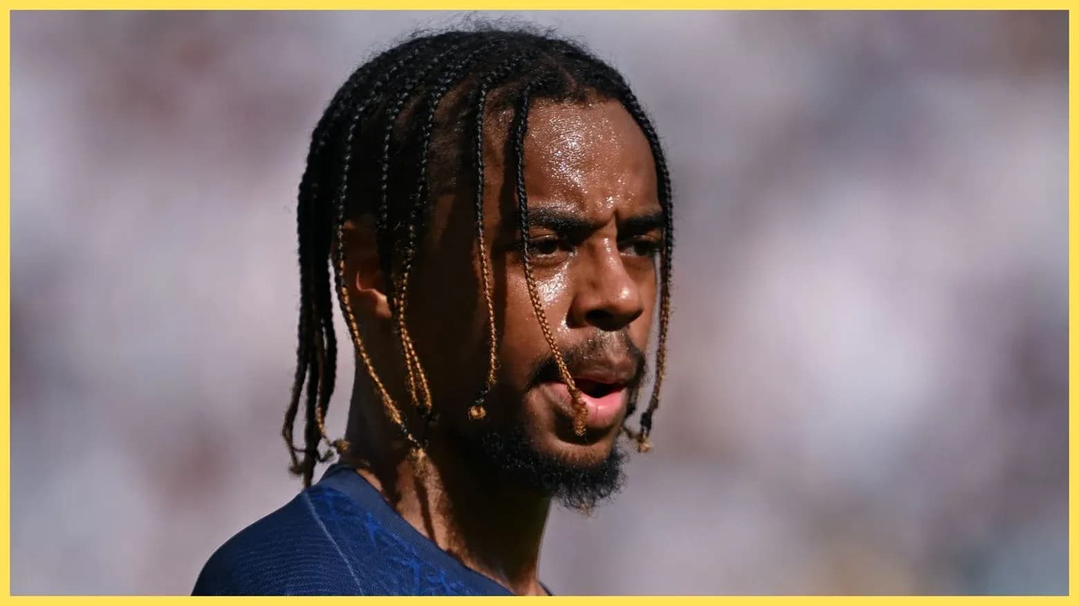 Jugador con trenzas durante un partido de fútbol Jugador con trenzas durante un partido de fútbol