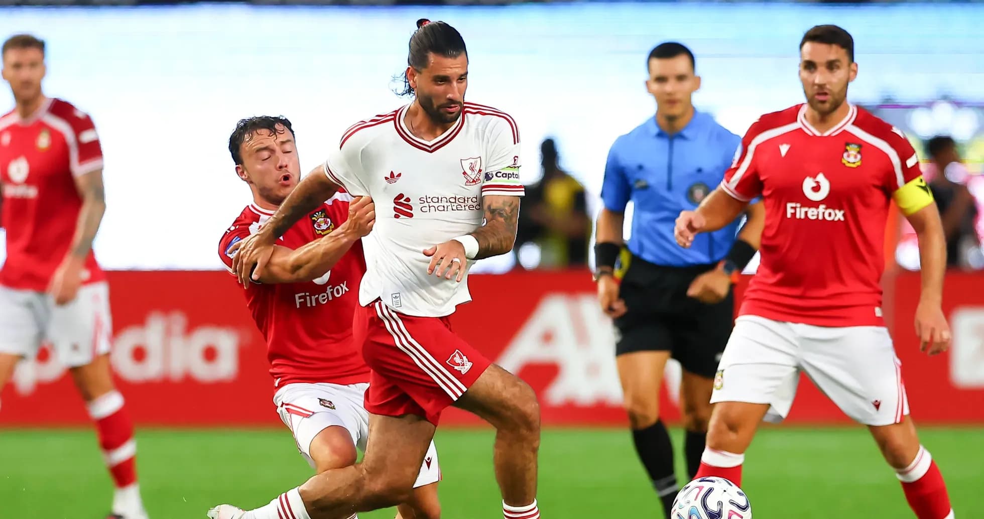 Jugador de Liverpool driblando mientras es marcado Jugador de Liverpool driblando mientras es marcado