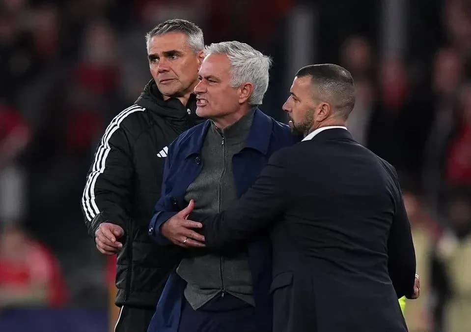 Entrenador siendo contenido por asistentes en el partido Entrenador siendo contenido por asistentes en el partido