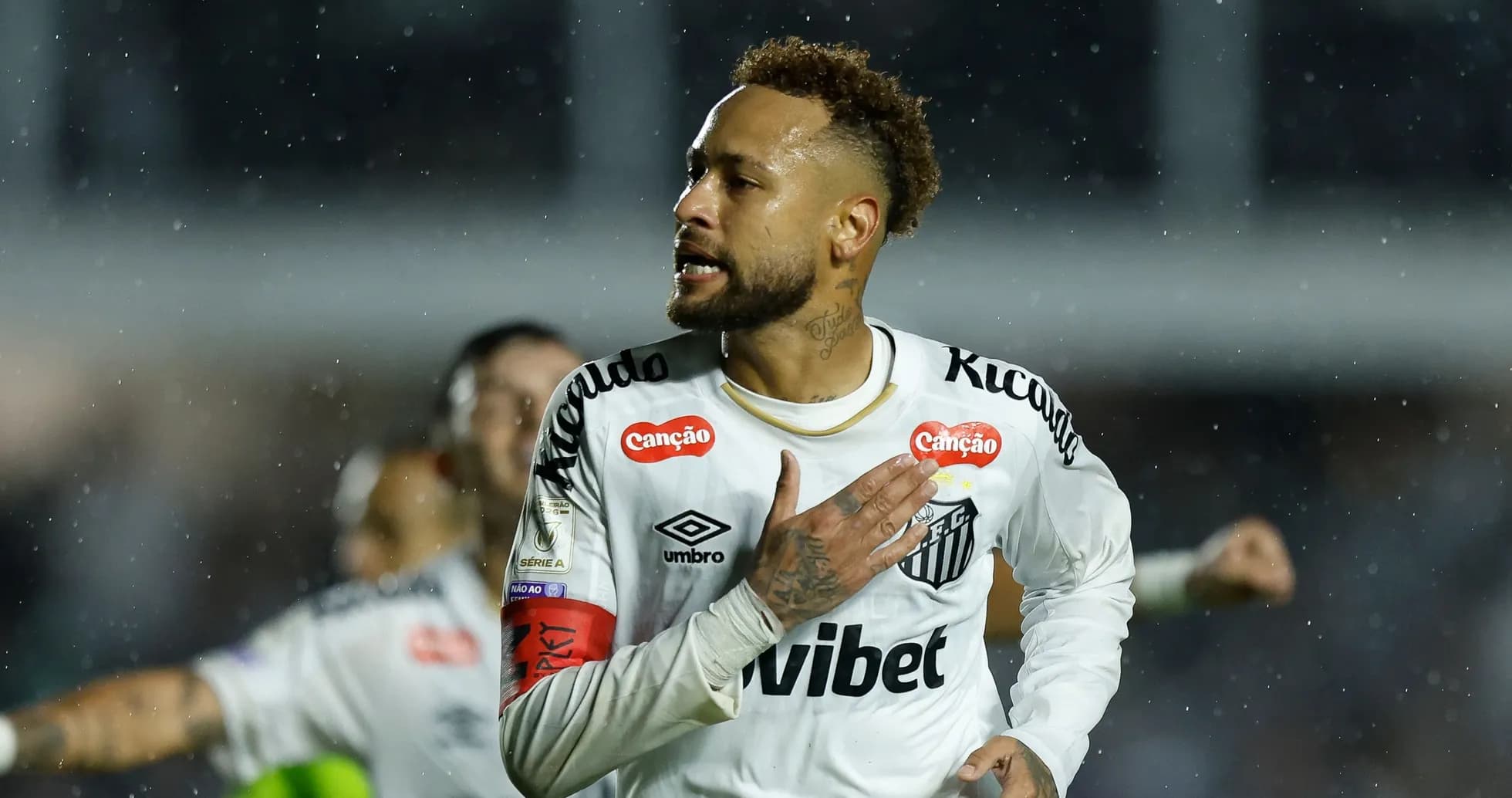 Jugador de Santos celebrando en la lluvia durante partido Jugador de Santos celebrando en la lluvia durante partido